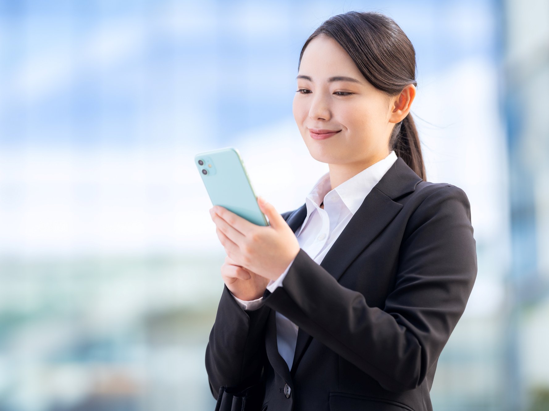 スーツでスマホを触る若者