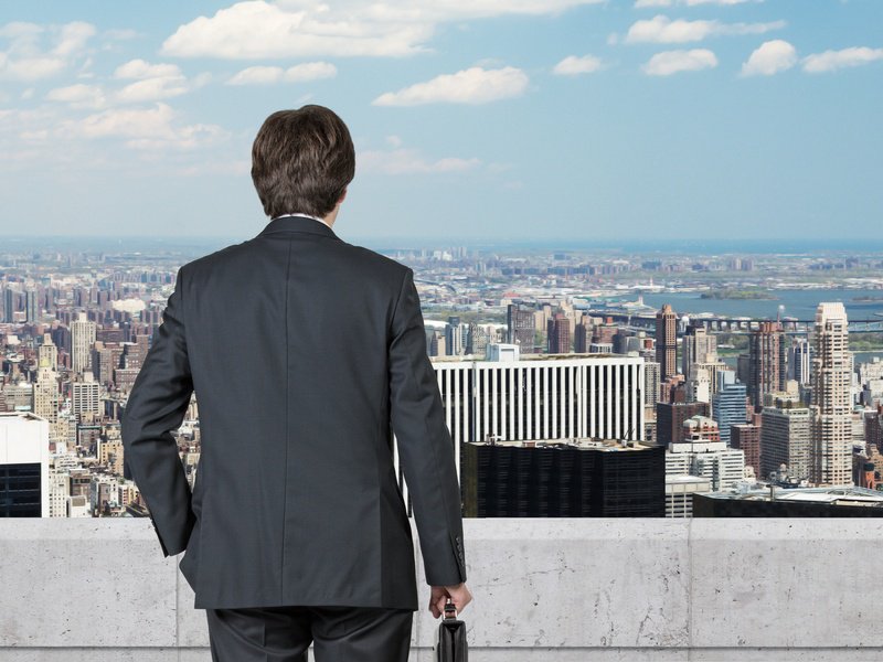 Back view of businessman with suitcase in hand