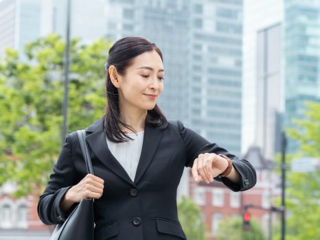 時計を見るスーツを着た日本の女性