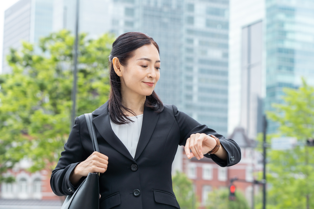 時計を見るスーツを着た日本の女性